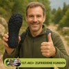 Lächelnder Mann in Outdoor-Kleidung auf Wanderweg hält Barfußschuhsohle in die Kamera und zeigt Daumen hoch; eingeblendeter Text: ‚137.483+ zufriedene Kunden‘ mit kleinen Kundenbildern