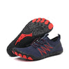 Blauer Barfußschuhe mit roten Details und zehenförmiger Profilsohle. Ein Schuh liegt flach, der andere zeigt die flexible Sohle mit rutschfestem Profil